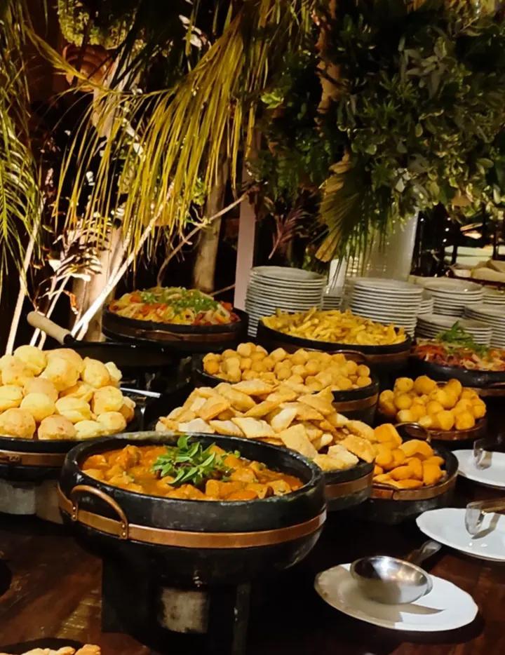 Coxinhas e salgados variados servidos em cumbucas com decoração floral