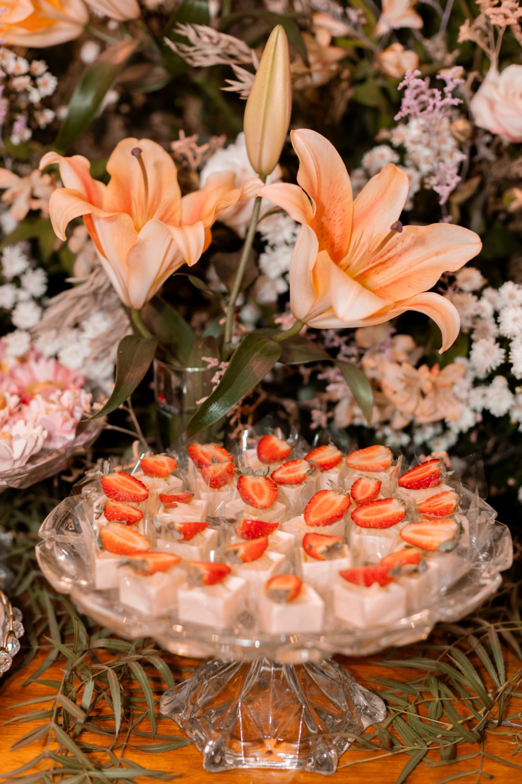 Mesa de doces com lírios e brigadeiros com morango